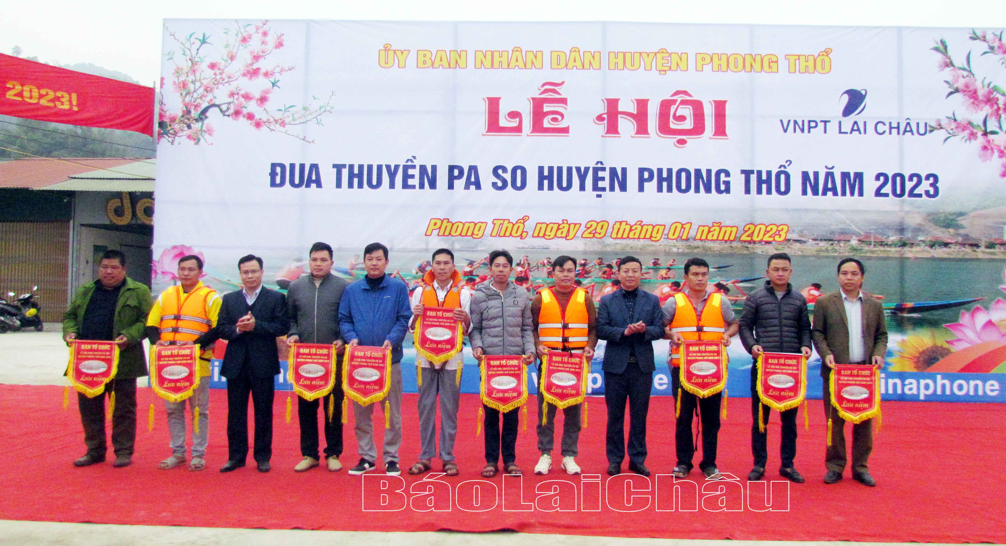 Lãnh đạo huyện Phong Thổ trao cờ lưu niệm cho các đội tham gia thi đua thuyền. 